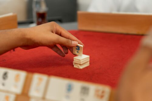 A hand arranging Okey tiles during a game session indoors in Yalova, Turkey.