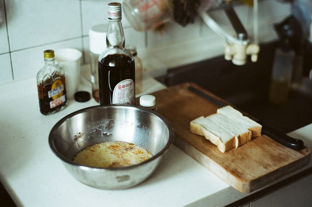 stainless steel bowl beside glass bottle